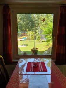 a table in front of a window with a view of a playground at Ferienwohnung am Wald in Biesenthal