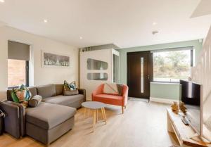 uma sala de estar com um sofá e uma televisão em Roe Cottage disabled adapted 2 bed cottage em Alcester