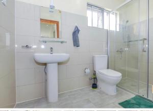 ein Bad mit einem WC, einem Waschbecken und einer Dusche in der Unterkunft Stunning 6-Bed Apartment in Kigali in Kigali