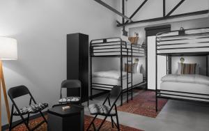 a room with three bunk beds and a table and chairs at Bposhtels SLC in Salt Lake City
