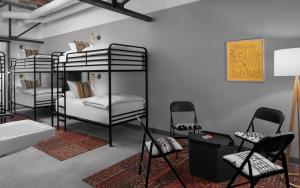 Cette chambre comprend 3 lits superposés avec des chaises et un lavabo. dans l'établissement Bposhtels SLC, à Salt Lake City