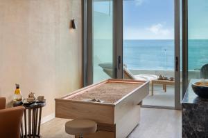 a bath tub in a room with a view of the ocean at EVOLUTION Cascais-Estoril Hotel in Estoril