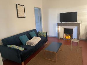 sala de estar con sofá azul y chimenea en Mas de L'isle en Bédarrides