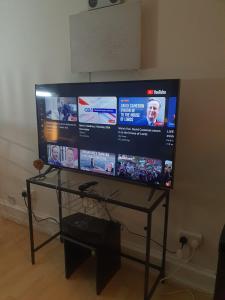 a large flat screen tv sitting on a glass table at BluepointPH in Abbey Wood