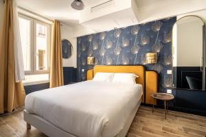 - une chambre avec un grand lit et un mur bleu dans l'établissement District Nation, à Paris