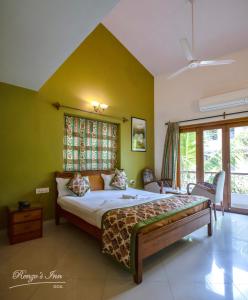 a bedroom with a large bed with green walls at Renzo's Inn in Calangute