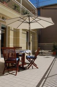 - une table et des chaises avec un parasol sur la terrasse dans l'établissement Souvenir 6, à Gabicce Mare