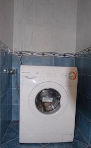 - un lave-linge dans la salle de bains dotée d'un mur en carrelage dans l'établissement Souvenir 6, à Gabicce Mare