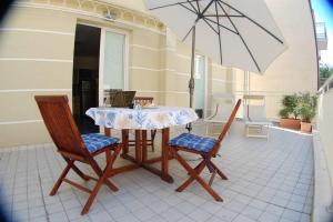 a table and chairs and an umbrella on a patio at Souvenir 6 in Gabicce Mare