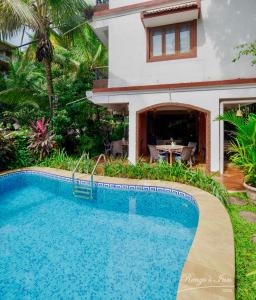 a swimming pool in front of a house at Renzo's Inn in Calangute