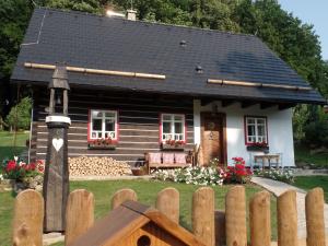 ein kleines Haus mit einem Zaun davor in der Unterkunft Penzion Roubenka in Hukvaldy