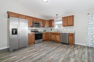 una cocina con armarios de madera y electrodomésticos de acero inoxidable en Home among the Nook in Hamilton Ohio, en Hamilton