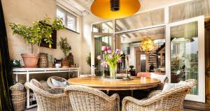een eetkamer met een tafel met stoelen en bloemen bij Maison Amodio in Brugge