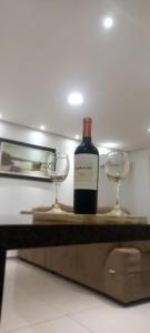 - une bouteille de vin et deux verres sur une table dans l'établissement Apartamentos na cobertura - Edifício London, à Piratuba