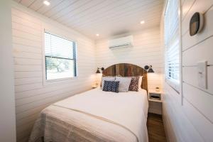 a bedroom in a tiny house with a bed at The Meadows Shipping Container Home in Bellmead