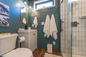 a bathroom with a toilet and a glass shower at The Meadows Shipping Container Home in Bellmead