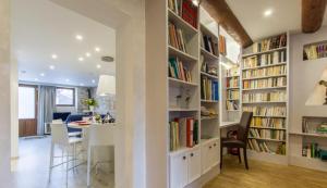 a library with white shelves filled with books at Le Clos Savoie Lorraine in Thônes