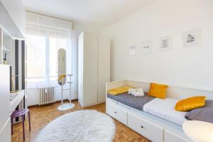Habitación blanca con cama con almohadas amarillas en Duomo-Fondazione Prada 10 min with M3- Large with veranda, en Milán