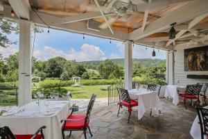 a patio with white tables and chairs and a large window at Ashby Inn & Restaurant in Paris