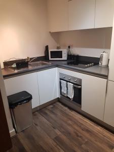 a small kitchen with a sink and a microwave at Stunning 1-Bed Apartment in Brierley Hill in Dudley