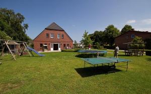 dos mesas de ping pong en un patio con una casa en Fru Hansen 9242VII - Fehmarn, en Fehmarn