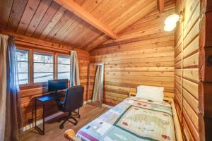 een slaapkamer in een blokhut met een bed en een bureau bij Pine Mountain Club Cabin Near Ferns Lake! in Frazier Park