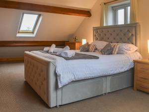 ein Schlafzimmer mit einem großen Bett mit weißer Bettwäsche und Kissen in der Unterkunft Oak Tree Cottage in Brierfield