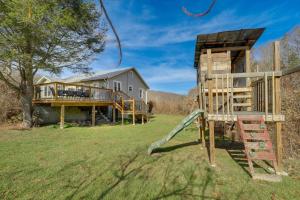 ein Haus mit einem Spielplatz und einem Haus in der Unterkunft Idyllic Blue Ridge Mountain Home on 26-Acre Farm in Roan Mountain