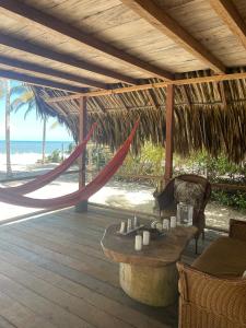 a porch with a hammock and a table on a beach at Reserva Natural El Matuy in Palomino