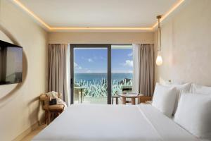 a bedroom with a bed and a view of the ocean at EVOLUTION Cascais-Estoril Hotel in Estoril