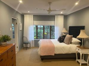 a bedroom with a large bed and a window at Lavender Cottage in Hillcrest