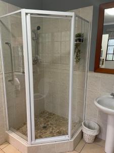 a shower with a glass door in a bathroom at Lavender Cottage in Hillcrest +22 photos