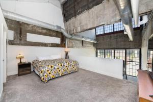 a bedroom with a bed in a large room with windows at Peters Cartridge Factory in Maineville
