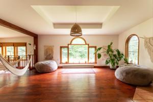 un soggiorno con pavimenti in legno e una grande finestra di Auberge Yoga Salamandre a Lac-Brome