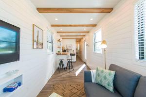 The Pecan Grove Container Home 15 min to Magnolia في Bellmead: غرفة معيشة مع أريكة وتلفزيون