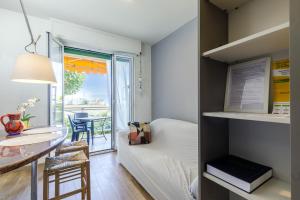 Appartamento-Sanremo my Home Free parking-Wi-fi في سانريمو: غرفة صغيرة بسرير وطاولة وبلكونة