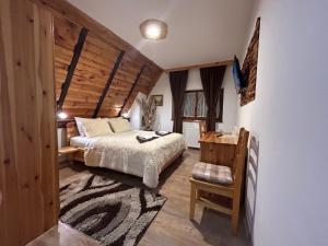 a bedroom with a bed and a wooden wall at Rustic Lodge Plitvice in Plitvička Jezera