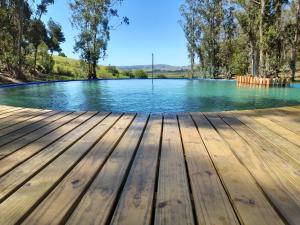 a pool of water with a wooden deck at Posada La Serena in Minas