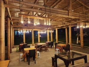 a restaurant with tables and chairs and lights at Finca Turística en Quindío cerca a Panaca in Quimbaya