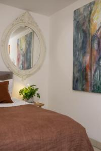 1 dormitorio con cama y espejo en la pared en The Luxury Inn, en Londres