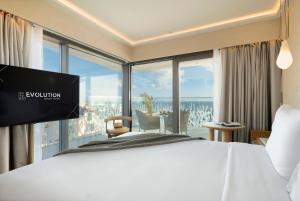 a hotel room with a bed and a large window at EVOLUTION Cascais-Estoril Hotel in Estoril