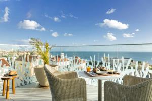 a balcony with a table and chairs and the ocean at EVOLUTION Cascais-Estoril Hotel in Estoril