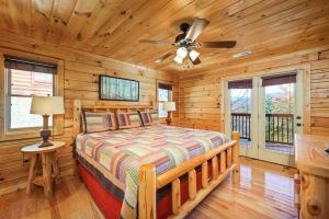 a bedroom with a bed and a ceiling fan at Spacious Smokies Cabin - Hot Tub with Mountain Views in Gatlinburg