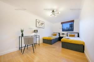 a bedroom with two beds and a table at Riverside Drive Apartment - Grampian Lettings Ltd in Aberdeen