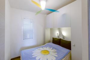 Appartamento-Sanremo my Home Free parking-Wi-fi في سانريمو: غرفة بها سرير مع وردة على السقف