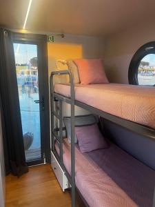 Casas Flotantes - Boatvillage في ايامونتي: سريرين بطابقين في غرفة صغيرة مع نافذة