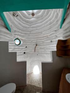 DOMOS PUJLLAI San Pedro de Atacama في سان بيدرو دي أتاكاما: حمام بسقف أبيض ومرحاض