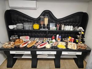 einen Tisch mit vielen verschiedenen Arten von Lebensmitteln in der Unterkunft Olympic Apartments Wellness & Spa in Belgrad