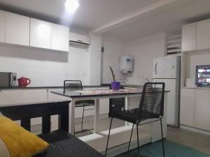 Una cocina con mesa y sillas y un refrigerador. en Amadeus, en Mendoza 5 fotos más