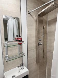 a bathroom with a shower and a sink and a mirror at Forces Manor in Kincraig